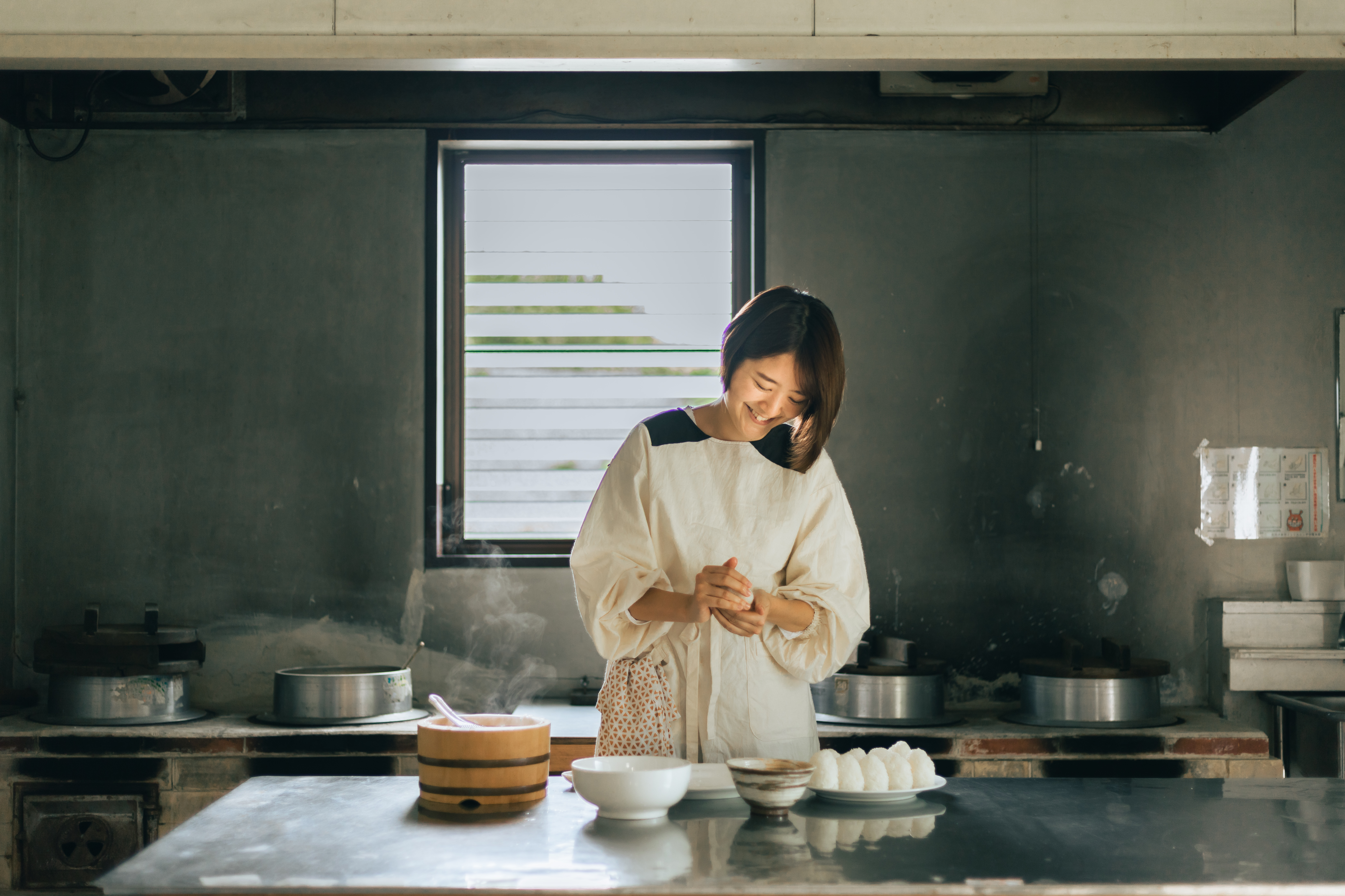 かまどのある台所でおむすびを作る講師